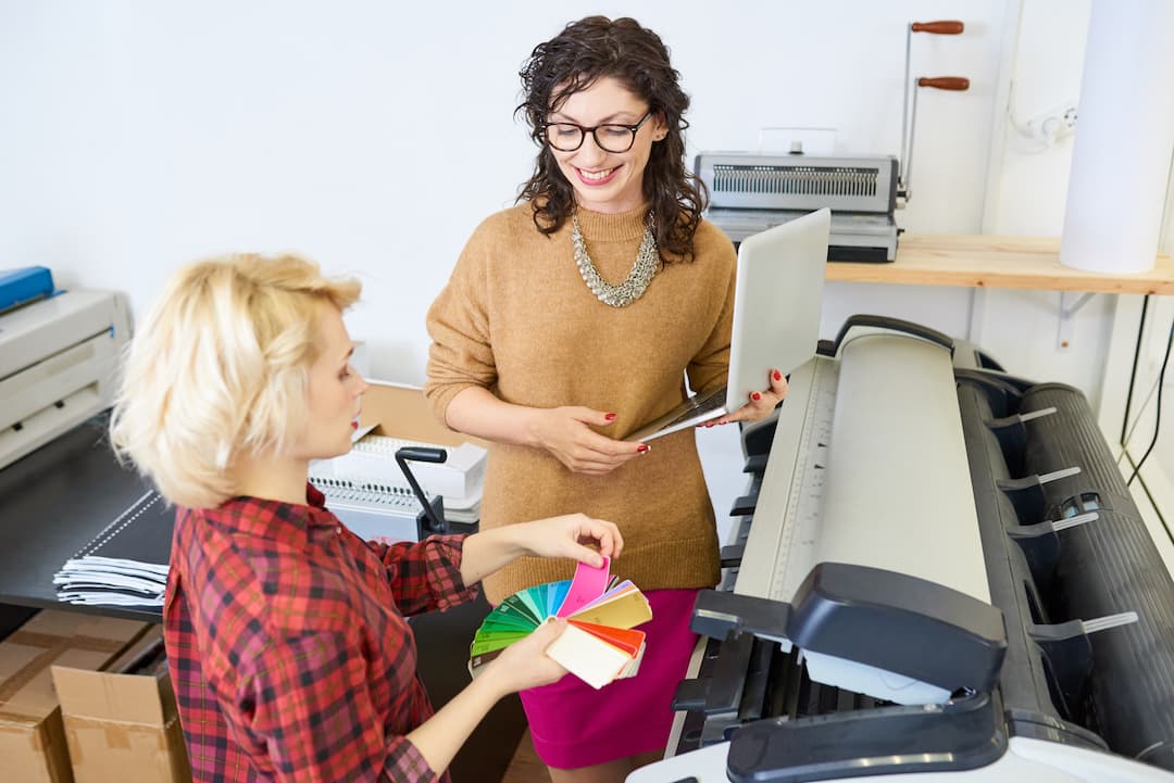 Two woman are happy after saving money on office printers